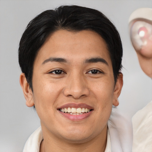 Joyful asian young-adult male with short  brown hair and brown eyes