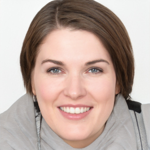 Joyful white young-adult female with medium  brown hair and grey eyes