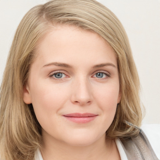 Joyful white young-adult female with long  brown hair and blue eyes