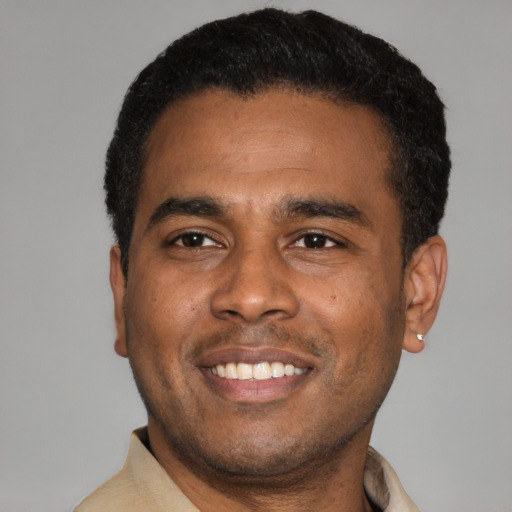 Joyful latino young-adult male with short  black hair and brown eyes
