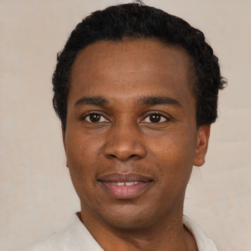 Joyful black young-adult male with short  black hair and brown eyes