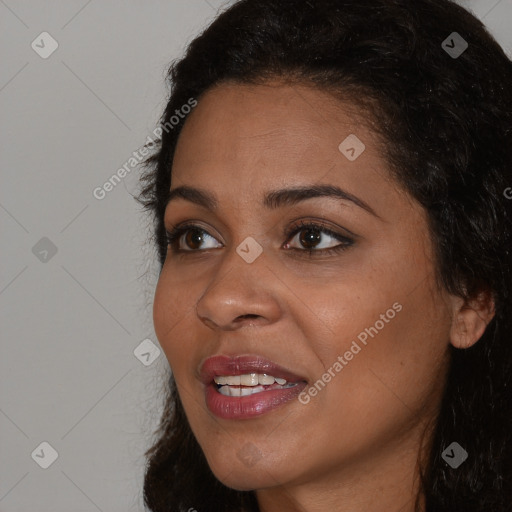 Joyful black young-adult female with long  brown hair and brown eyes