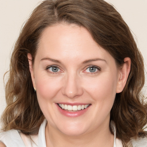 Joyful white young-adult female with medium  brown hair and grey eyes