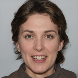 Joyful white adult female with medium  brown hair and blue eyes