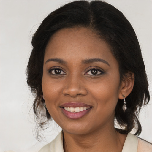Joyful black young-adult female with long  brown hair and brown eyes