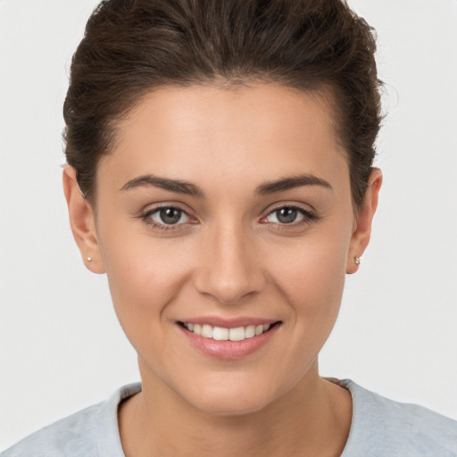 Joyful white young-adult female with short  brown hair and brown eyes