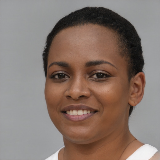 Joyful black young-adult female with short  brown hair and brown eyes