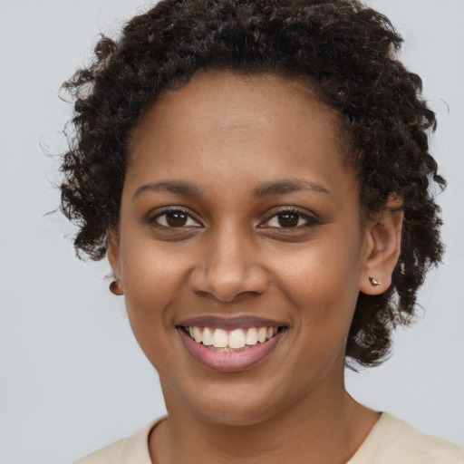 Joyful black young-adult female with medium  brown hair and brown eyes