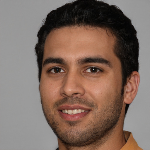 Joyful white young-adult male with short  black hair and brown eyes