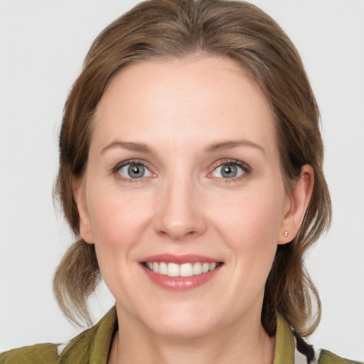 Joyful white young-adult female with medium  brown hair and grey eyes