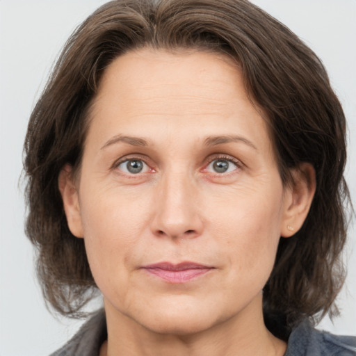 Joyful white adult female with medium  brown hair and grey eyes