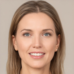 Joyful white young-adult female with long  brown hair and grey eyes