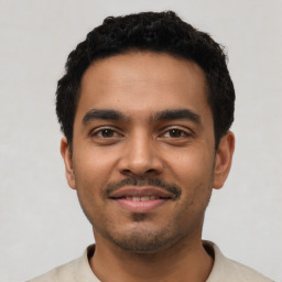 Joyful latino young-adult male with short  black hair and brown eyes