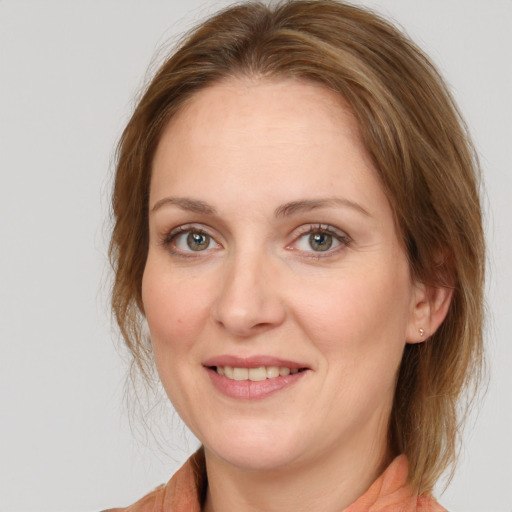 Joyful white young-adult female with medium  brown hair and grey eyes