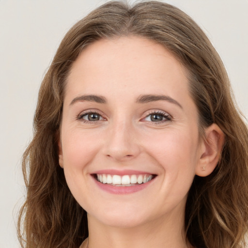 Joyful white young-adult female with long  brown hair and green eyes