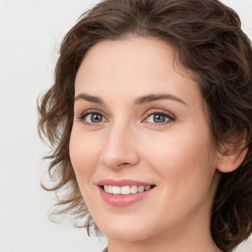 Joyful white young-adult female with medium  brown hair and green eyes