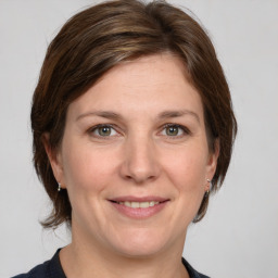 Joyful white adult female with medium  brown hair and grey eyes