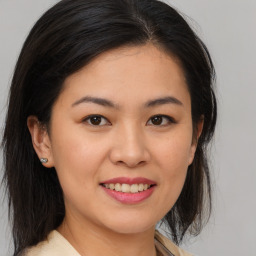 Joyful asian young-adult female with medium  brown hair and brown eyes