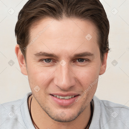 Joyful white young-adult male with short  brown hair and grey eyes