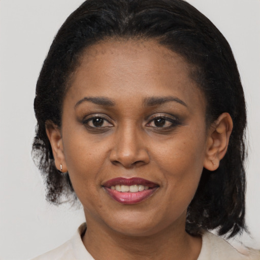 Joyful black adult female with medium  brown hair and brown eyes