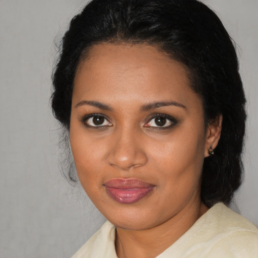 Joyful black young-adult female with medium  black hair and brown eyes