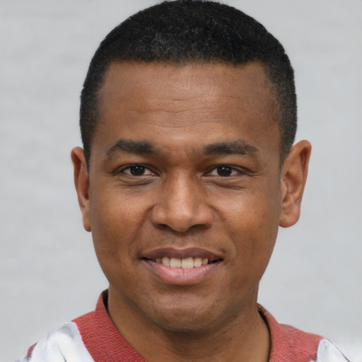 Joyful black young-adult male with short  black hair and brown eyes