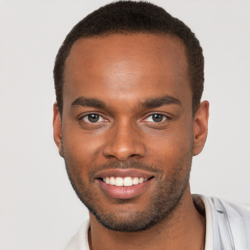 Joyful black young-adult male with short  brown hair and brown eyes