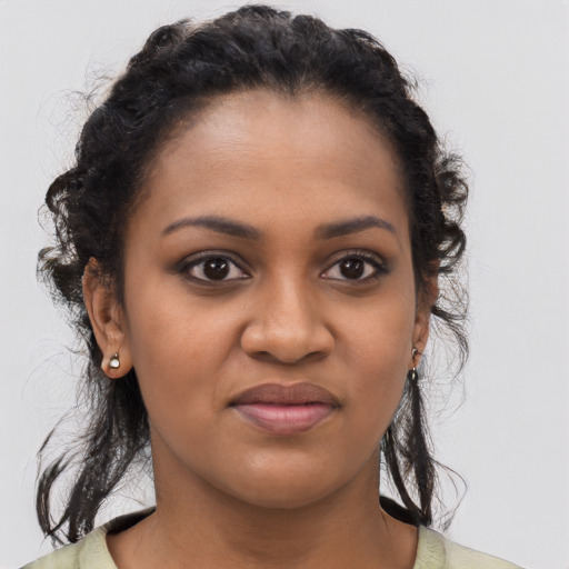 Joyful black young-adult female with long  brown hair and brown eyes