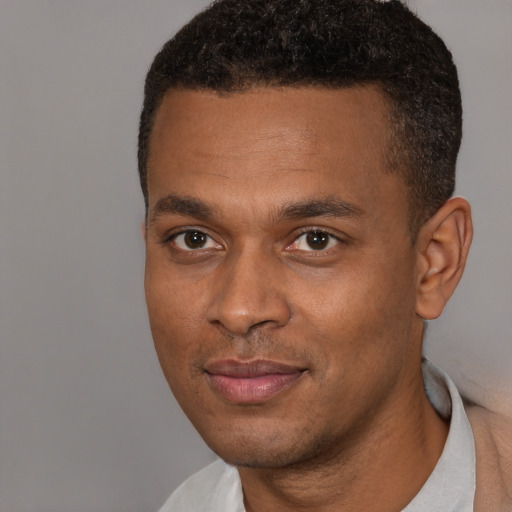 Joyful black young-adult male with short  black hair and brown eyes
