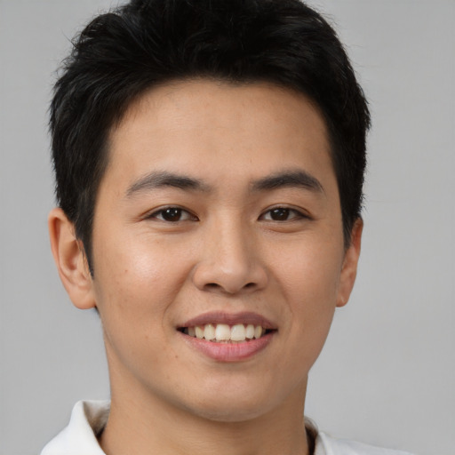 Joyful asian young-adult male with short  brown hair and brown eyes