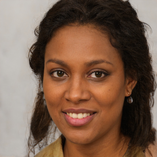 Joyful black young-adult female with long  brown hair and brown eyes