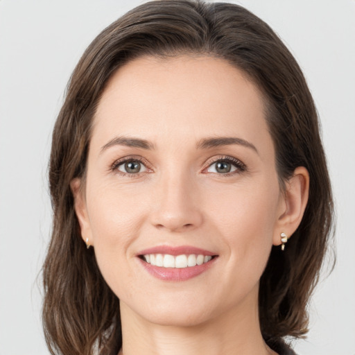 Joyful white young-adult female with medium  brown hair and grey eyes