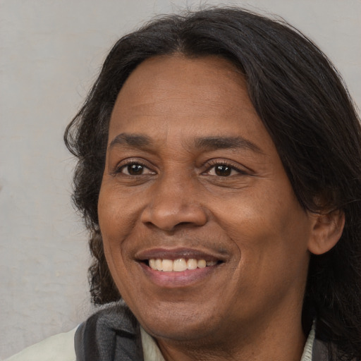 Joyful white adult male with long  brown hair and brown eyes
