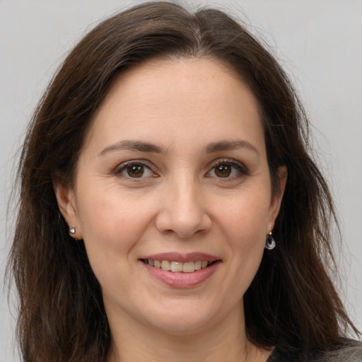 Joyful white adult female with long  brown hair and brown eyes