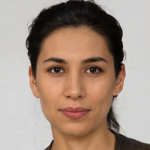 Joyful latino young-adult female with short  brown hair and brown eyes