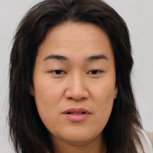 Joyful asian young-adult female with long  brown hair and brown eyes