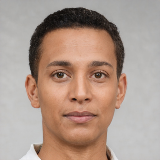 Joyful latino young-adult male with short  brown hair and brown eyes