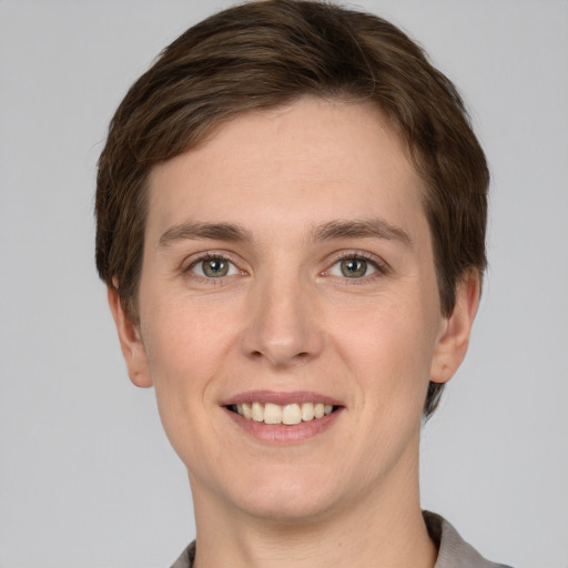 Joyful white young-adult female with short  brown hair and grey eyes