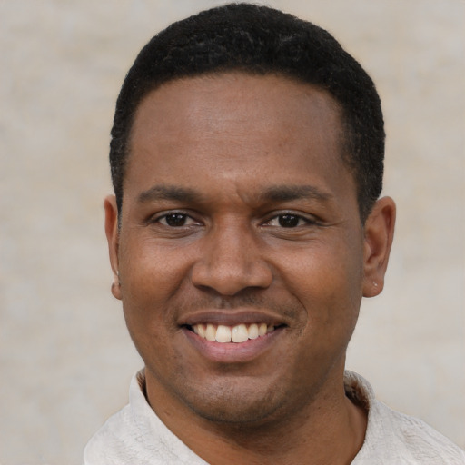 Joyful black young-adult male with short  black hair and brown eyes