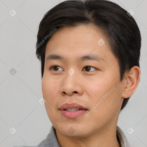 Joyful asian young-adult male with short  black hair and brown eyes