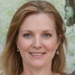 Joyful white adult female with medium  brown hair and blue eyes