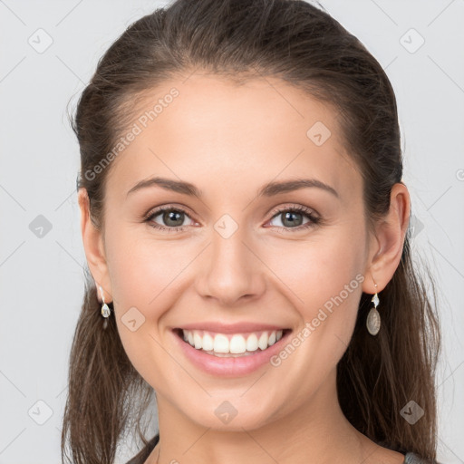 Joyful white young-adult female with long  brown hair and grey eyes