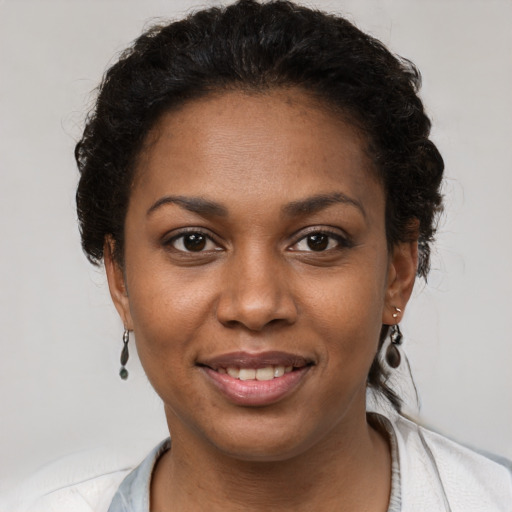 Joyful black young-adult female with short  brown hair and brown eyes