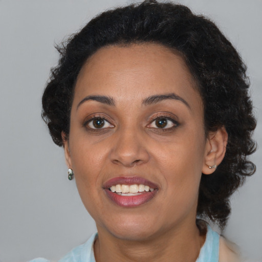 Joyful black young-adult female with short  brown hair and brown eyes