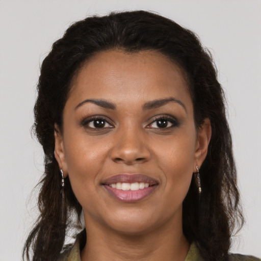 Joyful black young-adult female with long  brown hair and brown eyes