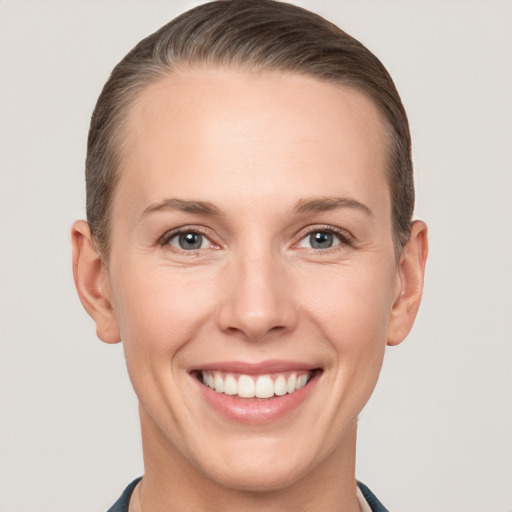 Joyful white young-adult female with short  brown hair and grey eyes