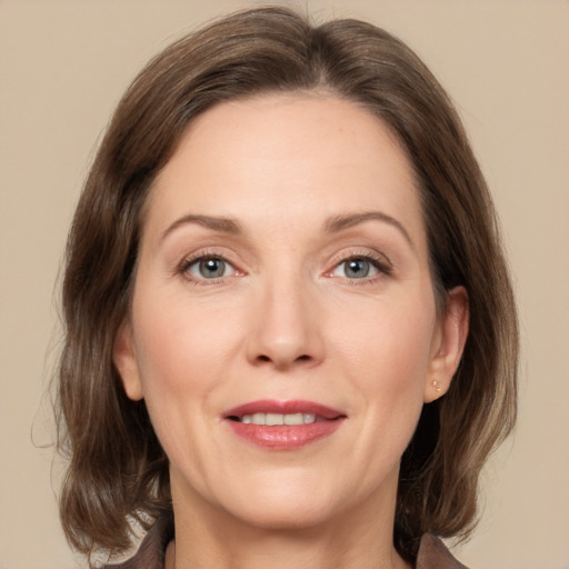 Joyful white adult female with medium  brown hair and grey eyes