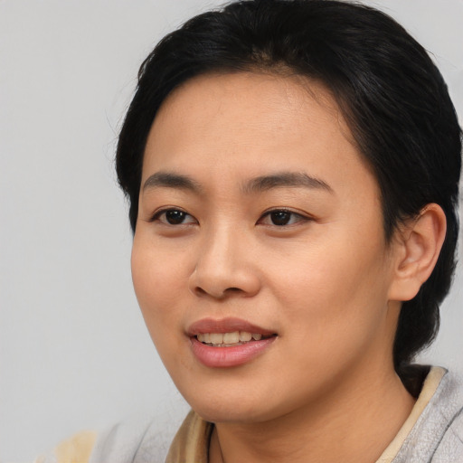 Joyful asian young-adult female with short  black hair and brown eyes