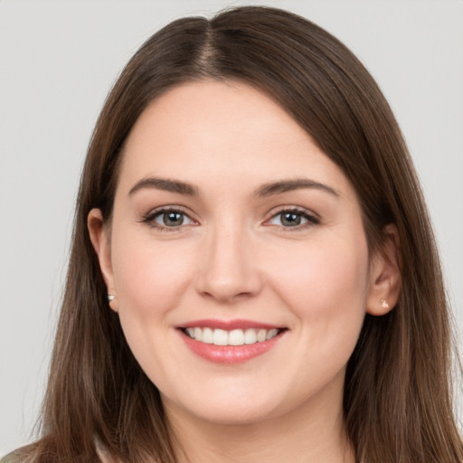 Joyful white young-adult female with long  brown hair and brown eyes