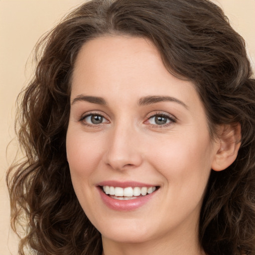 Joyful white young-adult female with long  brown hair and brown eyes